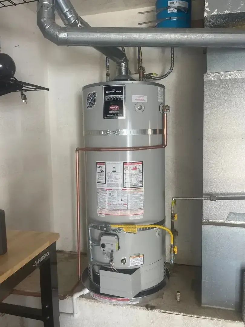 Gray water heater tank with copper pipes in utility room