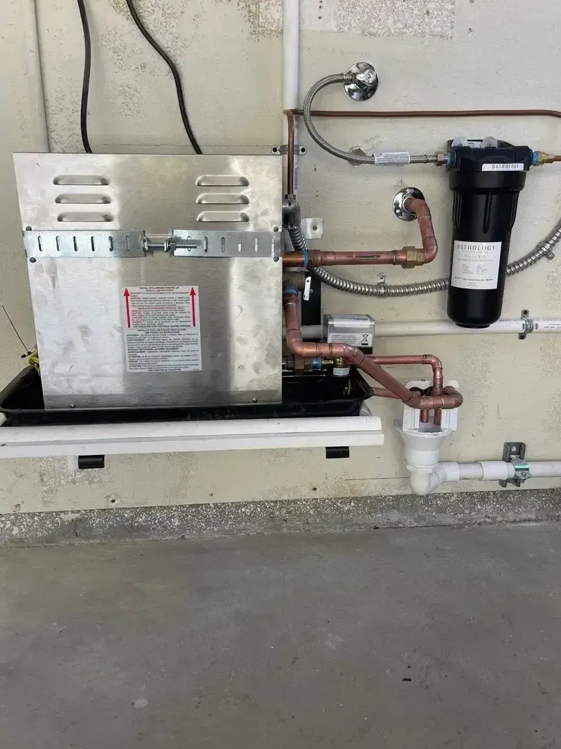 Tankless water heater with copper pipes and filter system in garage